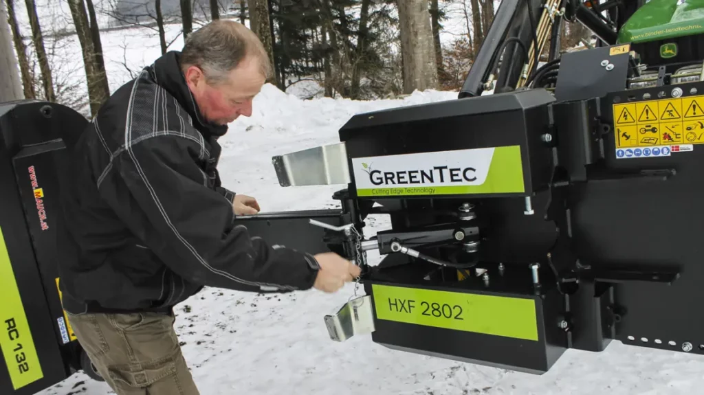 Johann unfolds the hedge cutting tool from transport to working position