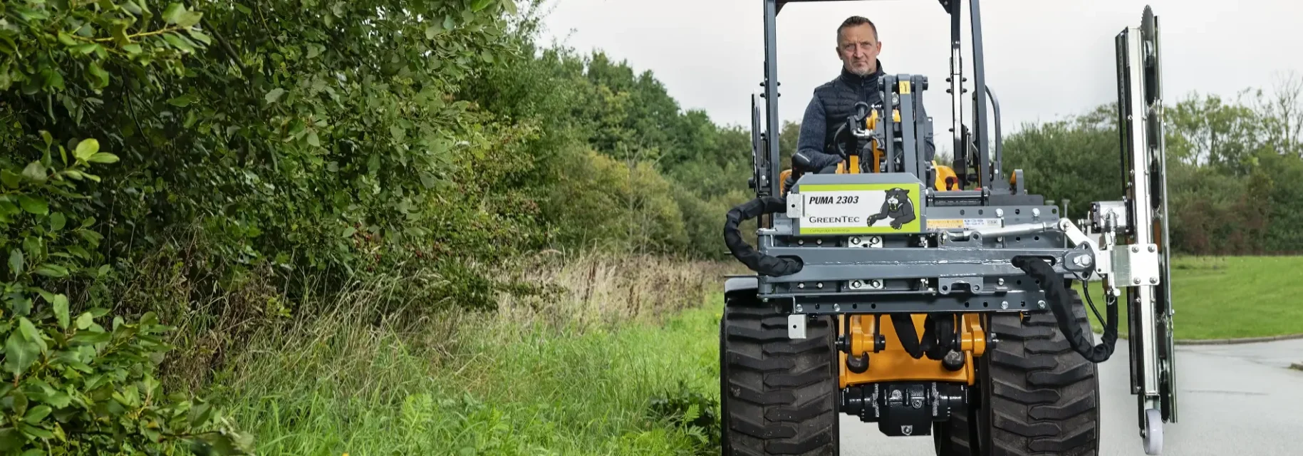 Hegnsklipper i transportposition på minilæsser