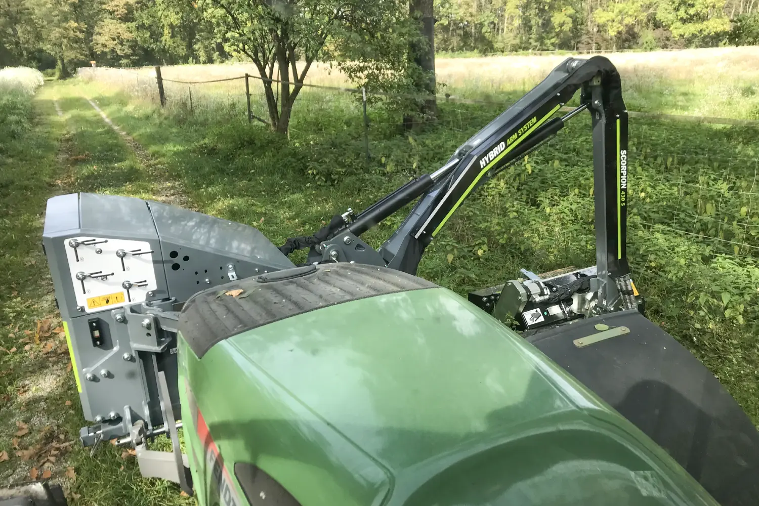 Grass mowing on narrow path near grassland